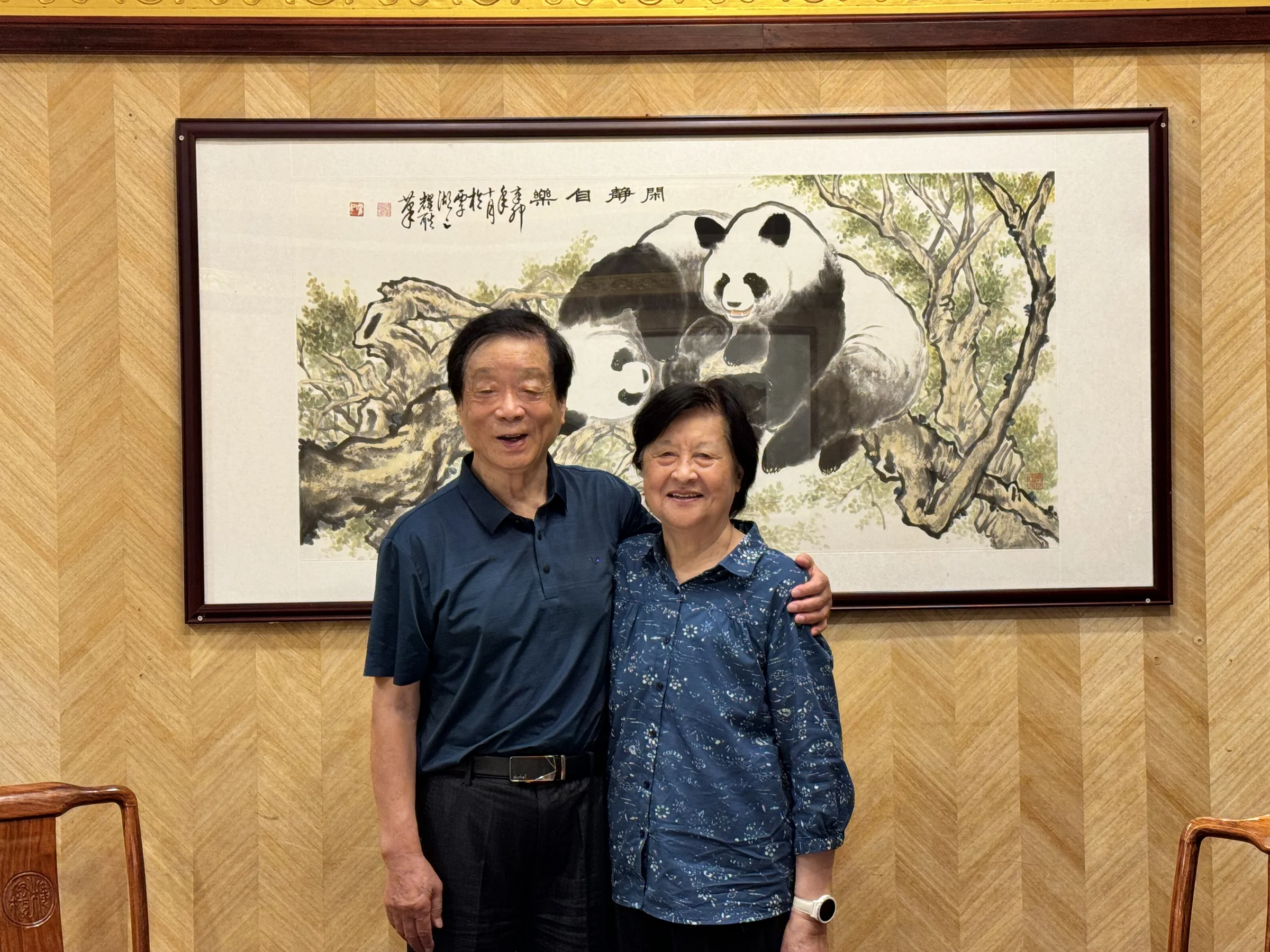 My maternal grandparents beside a panda painting